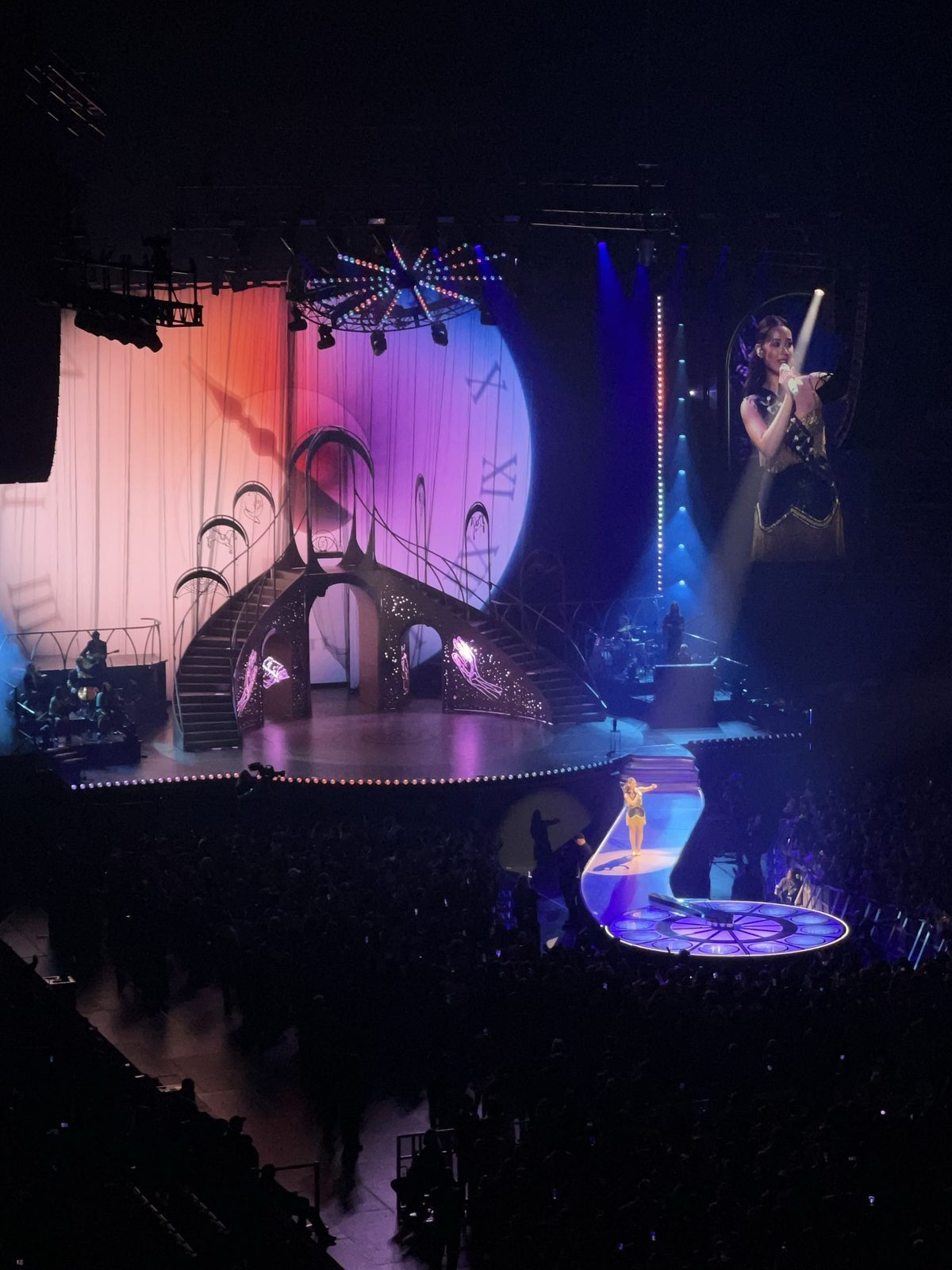 Laufey performing on the A Matter of Time North America Tour, Oct 2025, an ornate staircase stage set lit in pink and blue
